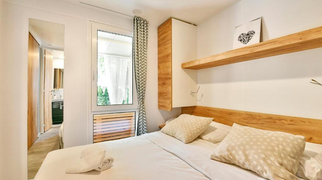a bedroom with a white bed and a window at Polidor Camping Resort in Poreč
