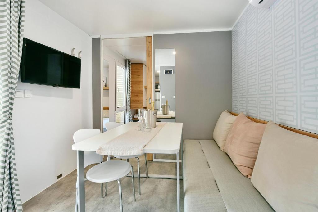 a living room with a white table and a couch at Polidor Camping Resort in Poreč