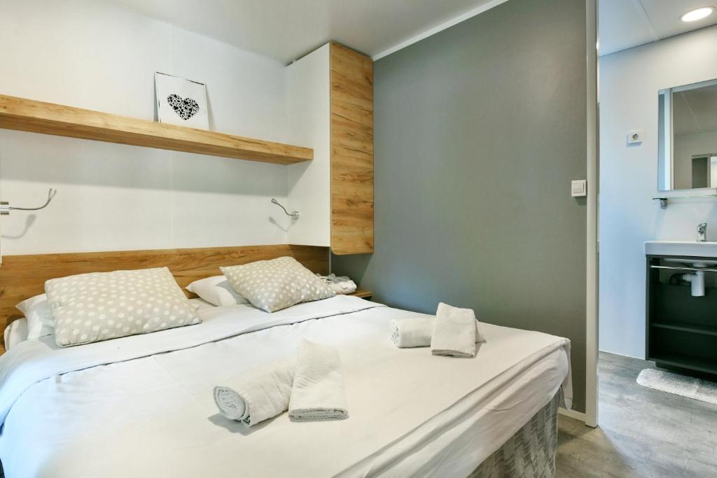 two beds in a small room with a sink at Polidor Camping Resort in Poreč