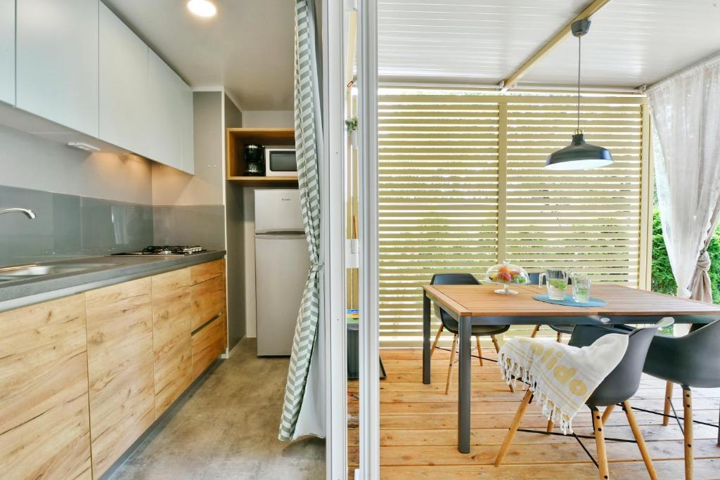 a kitchen and dining room with a table and chairs at Polidor Camping Resort in Poreč