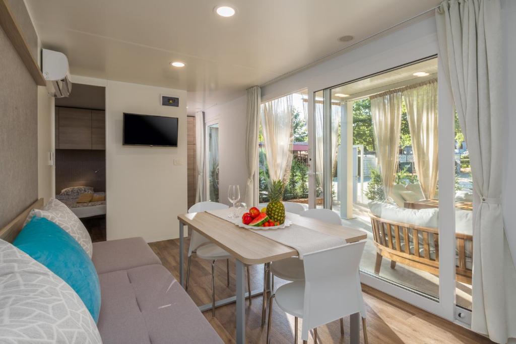 a bedroom and living room with a table and chairs at Polidor Camping Resort in Poreč