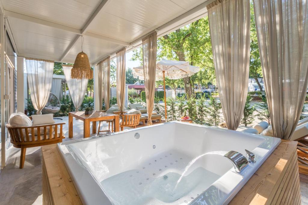 a large bath tub in a room with windows at Polidor Camping Resort in Poreč
