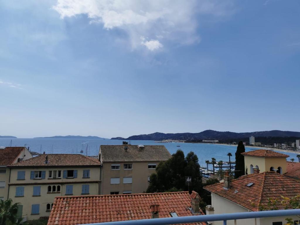 vista para a água dos telhados dos edifícios em Superbe Appartement avec terrasse vue mer em Le Lavandou