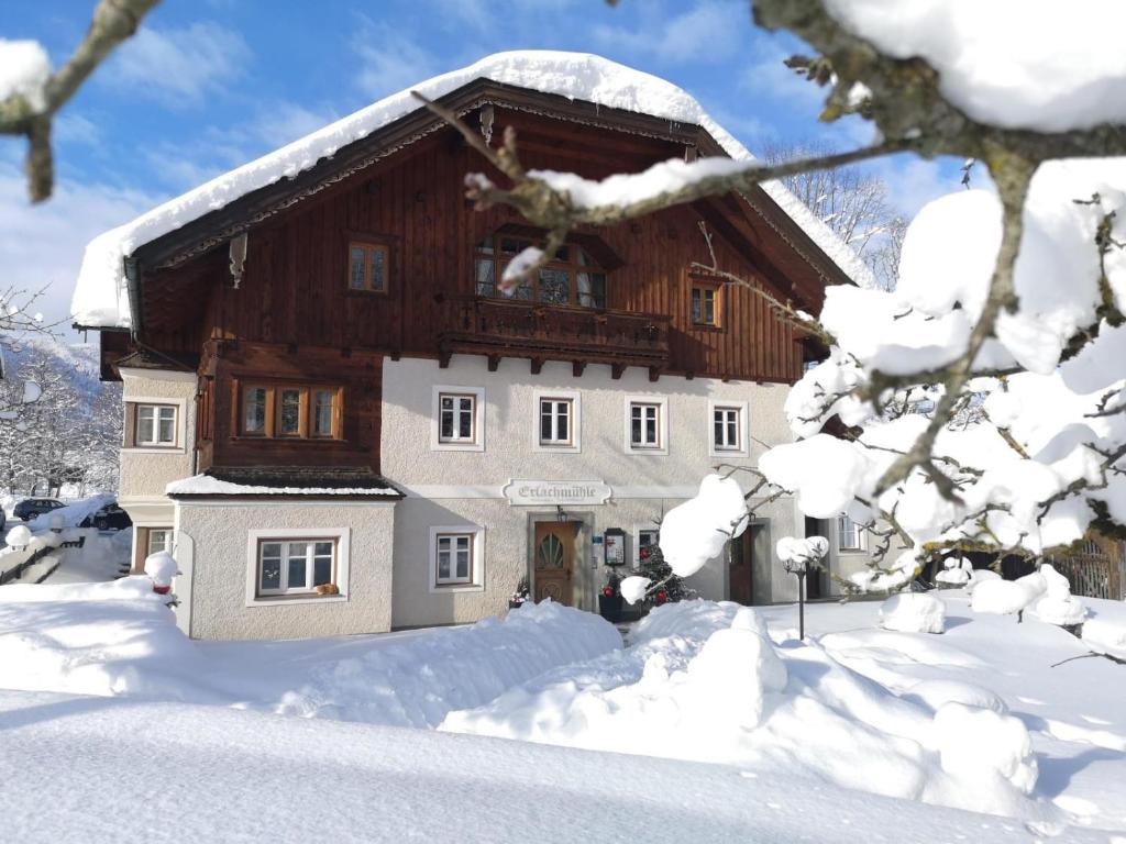 a house covered in snow with snow covered trees at Erlachmühle in Mondsee
