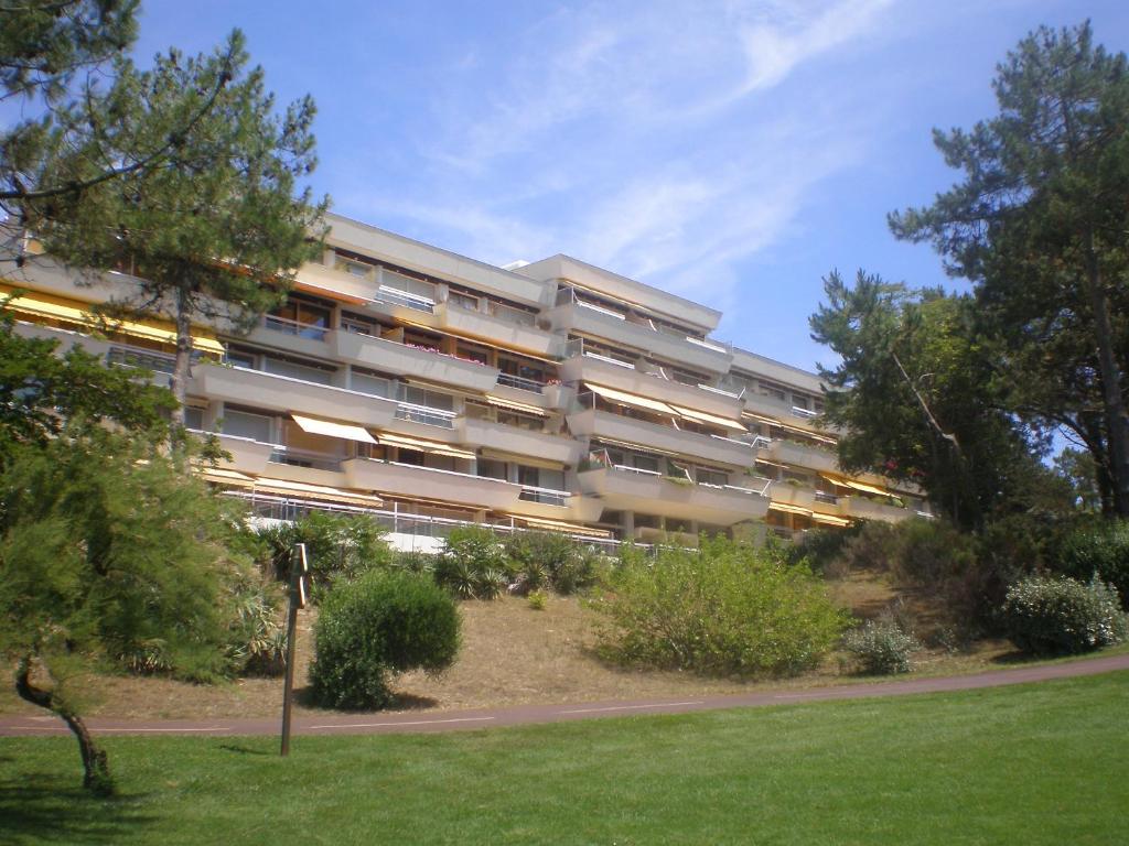 un immeuble d'appartements avec un parc en face de celui-ci dans l'établissement Appartement standing front de mer Arcachon, à Arcachon