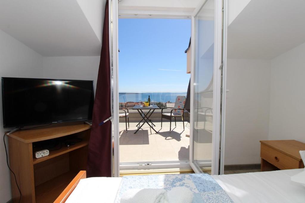 sypialnia z łóżkiem i widokiem na patio w obiekcie Apartments Karas on the island of Pag w mieście Mandre