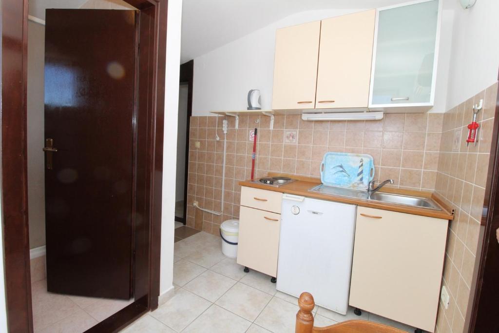 małą kuchnię ze zlewem i toaletą w obiekcie Apartments Karas on the island of Pag w mieście Mandre