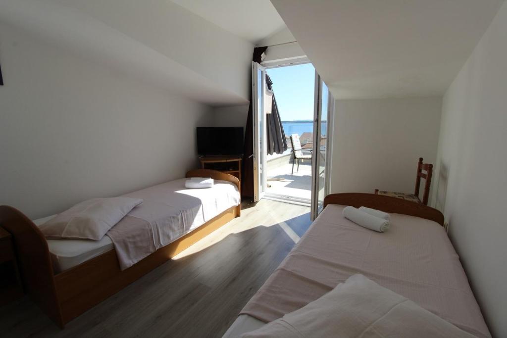 sypialnia z dwoma łóżkami i balkonem w obiekcie Apartments Karas on the island of Pag w mieście Mandre