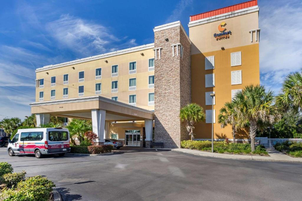 a hotel with a van parked in a parking lot at Comfort Suites At Fairgrounds-Casino in Tampa