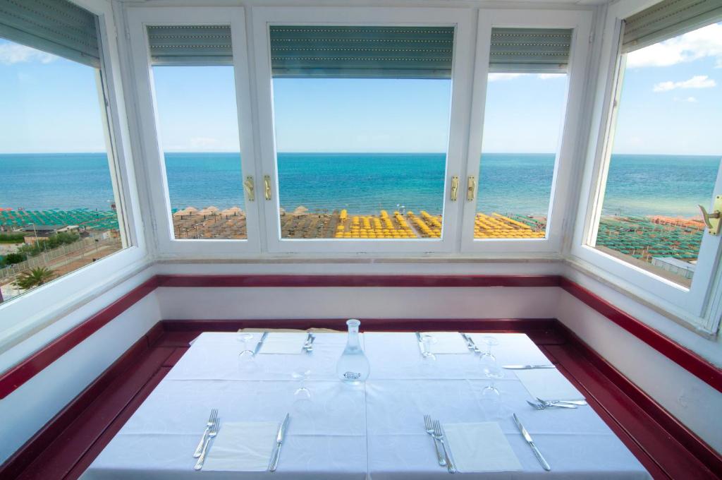 una sala da pranzo con vista sull'oceano di Hotel Nettuno a Pesaro