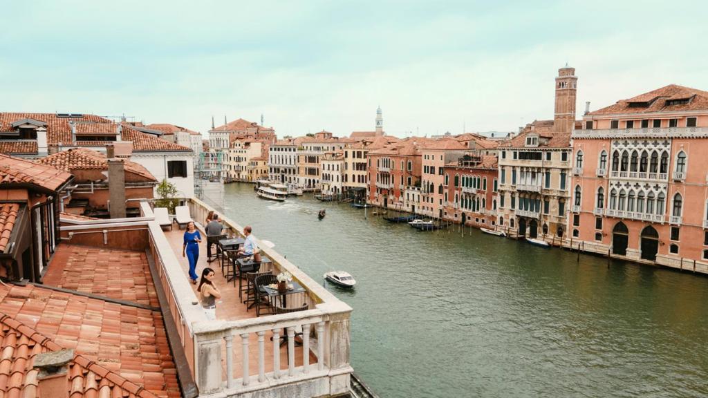 a group of people standing on a bridge over a river at Palazzo Barocci in Venice