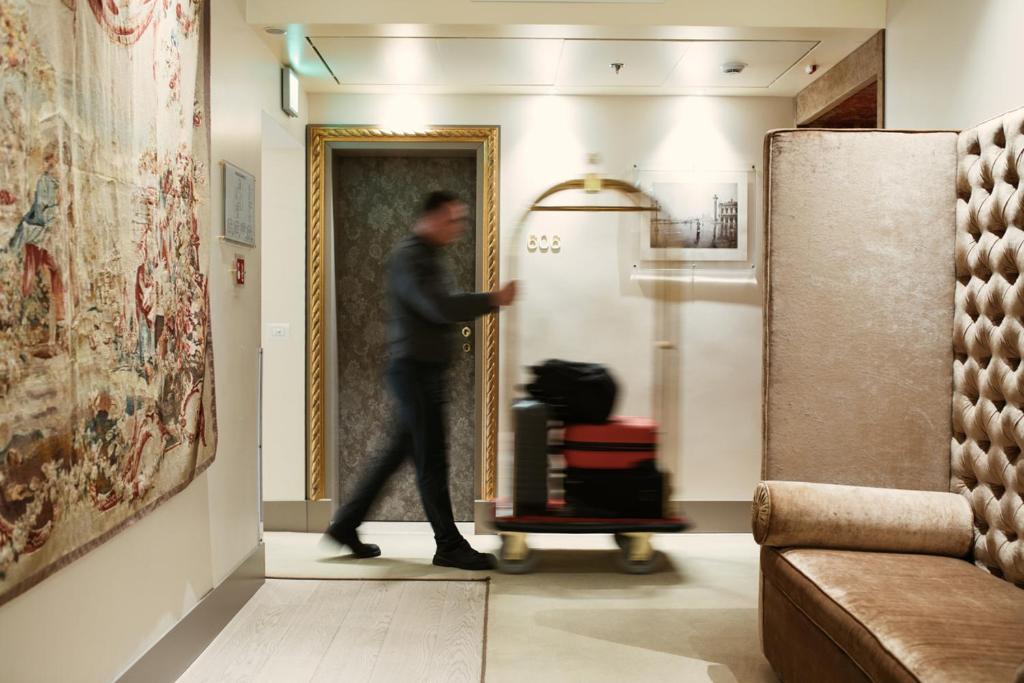 a man walking into a room with a refrigerator at Palazzo Barocci in Venice