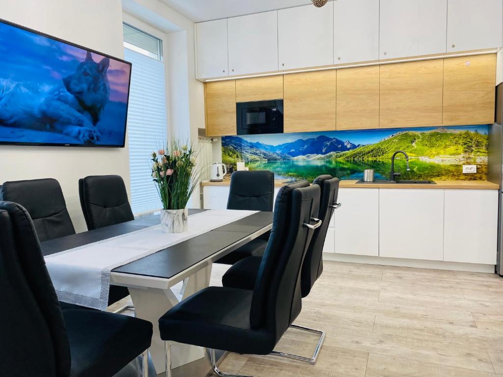 a dining room with a table and chairs and a tv at Apartament Rodzinny Centrum Zakopane in Zakopane