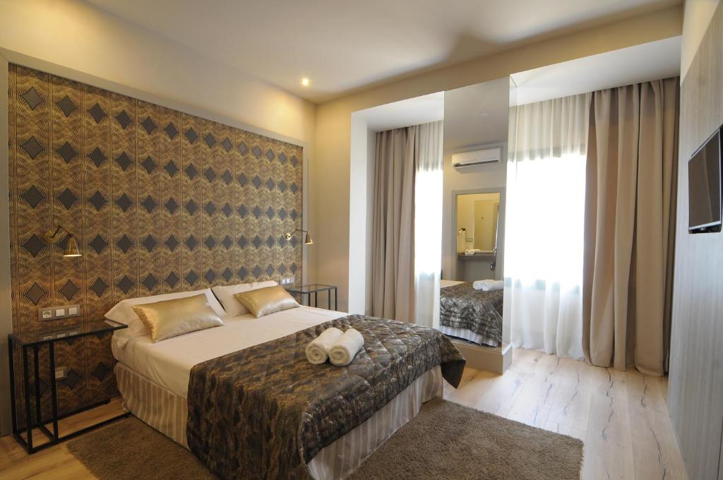 バルセロナにあるカーサ バルメスのベッドと大きな窓が備わるホテルルームです。