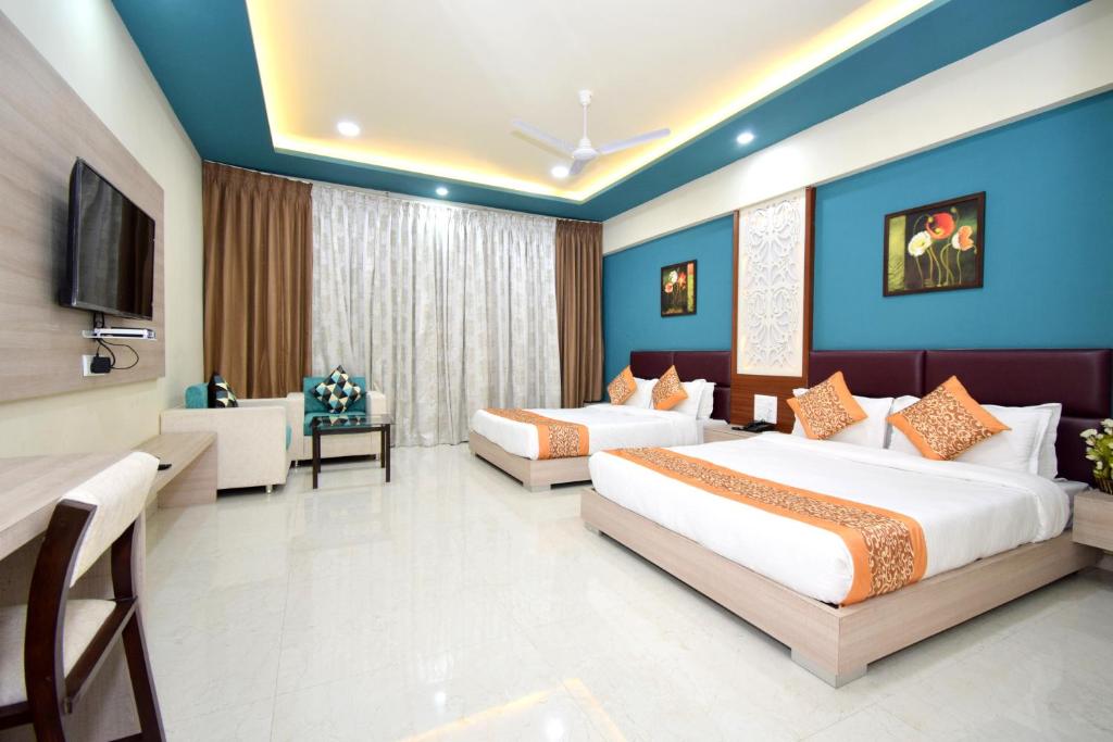 um quarto de hotel com duas camas e uma televisão em The Sky Imperial- Hotel Gopal Darshan em Nathdwara