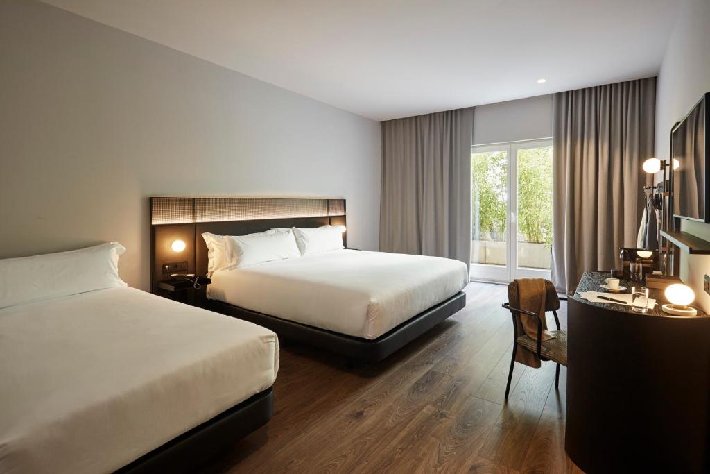 a hotel room with two beds and a window at Chic & Basic Gravity in Porto