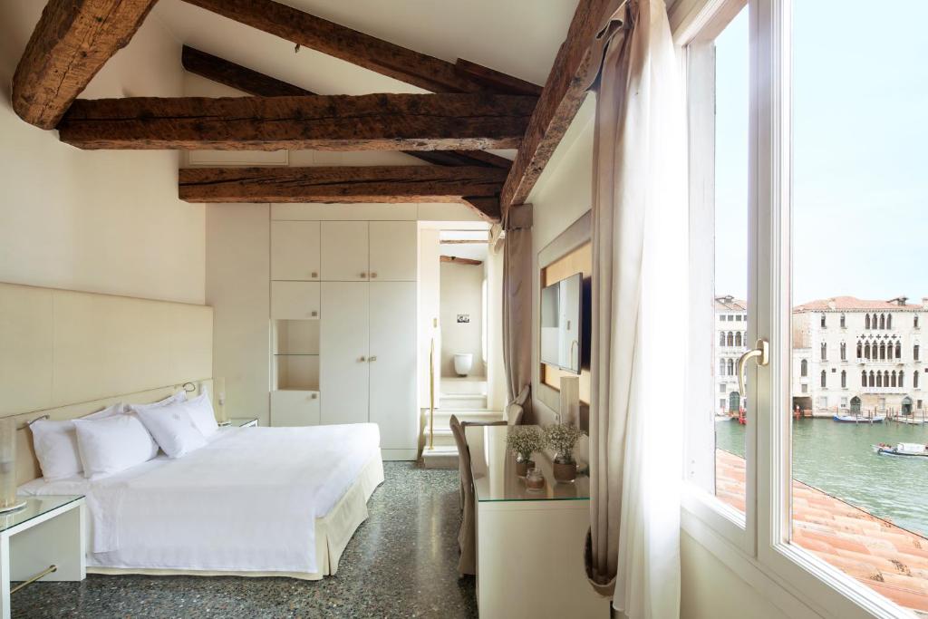 a bedroom with a bed and a large window at Palazzo Barocci in Venice
