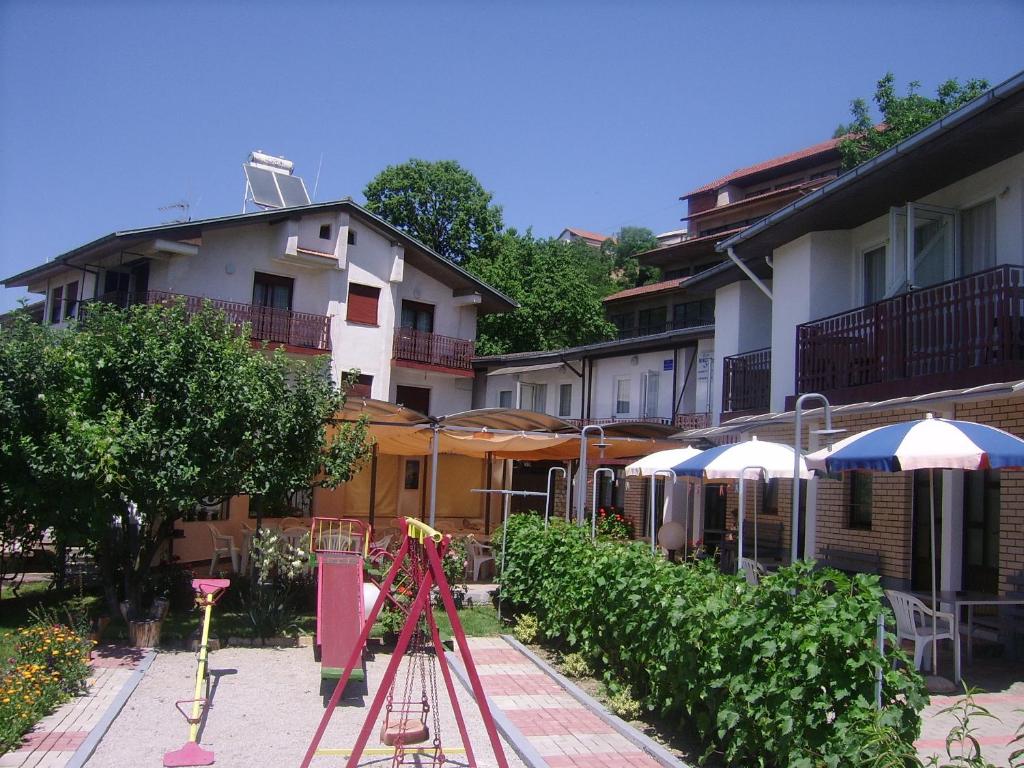 un grupo de sombrillas y un trípode frente a un edificio en Villa Nikola Ohrid, en Ohrid