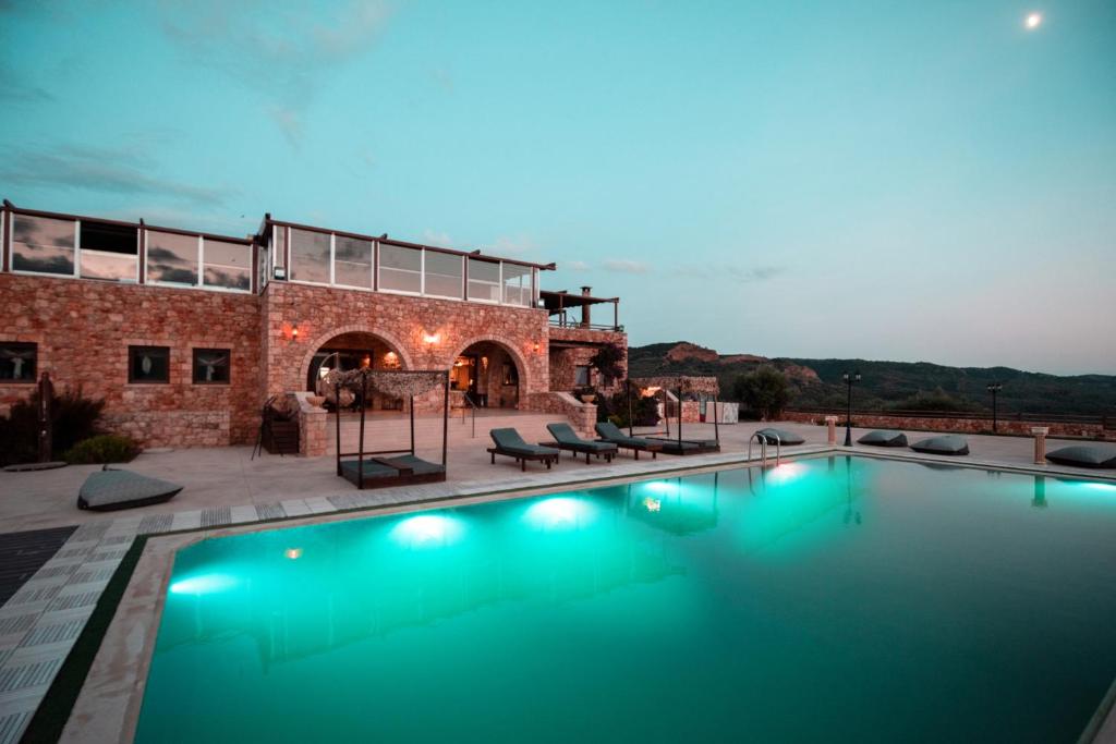 a swimming pool in front of a building at Melies Hotel in Kokkinórrakhi