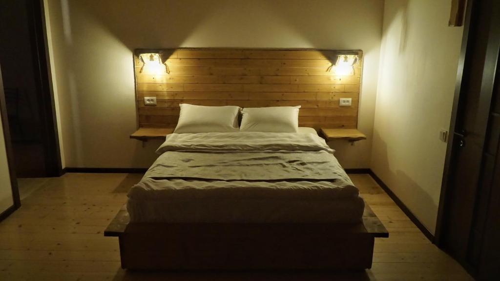 a large bed in a small room with two pillows at Mansarda Kazbegi in Kazbegi