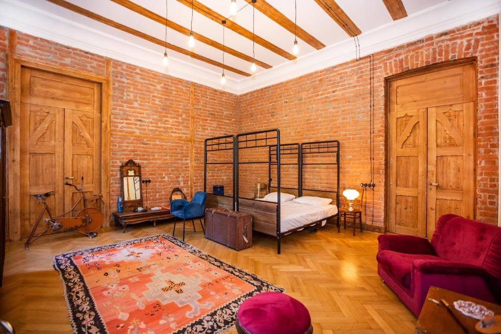 a room with a bed and a brick wall at Majestic Historic Apartment in Tbilisi City