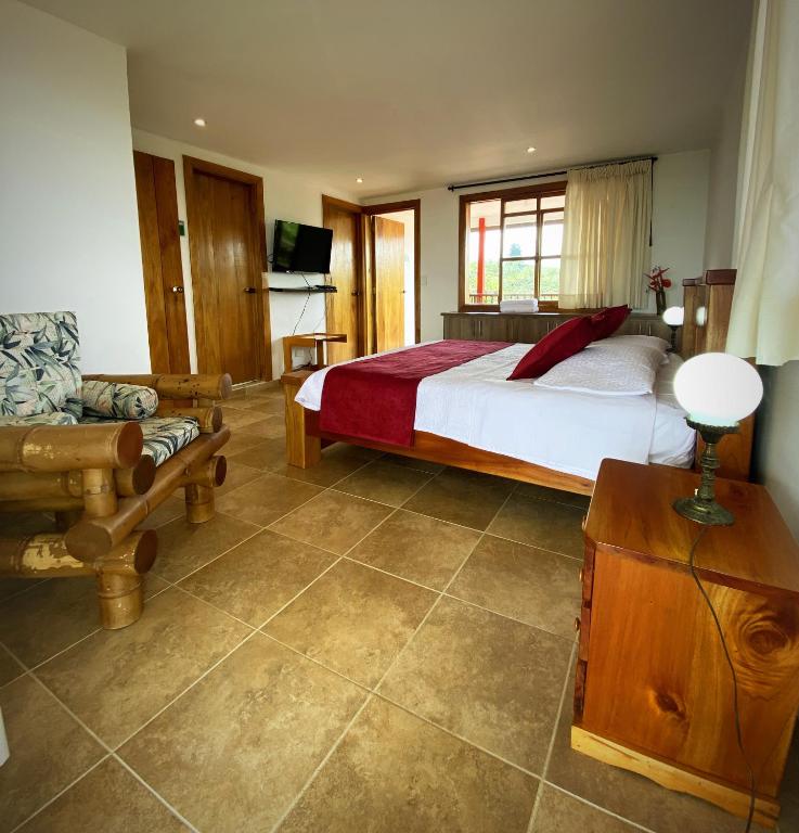 a bedroom with a bed and a couch and a television at Casa Chute in Chinchiná