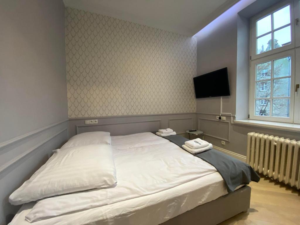 a bedroom with a bed with two towels on it at Maya's Flats & Resorts 44 - 3 rooms apartment on Chlebnicka Street Gdańsk Old Town in Gdańsk