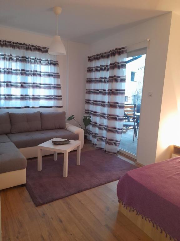 a living room with a couch and a table at V & V Studio Apartments in Niš