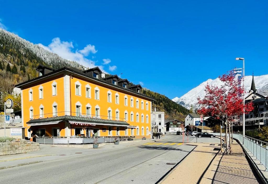 un edificio giallo sul lato di una strada di Boutique und Bier Hotel des alpes a Fiesch
