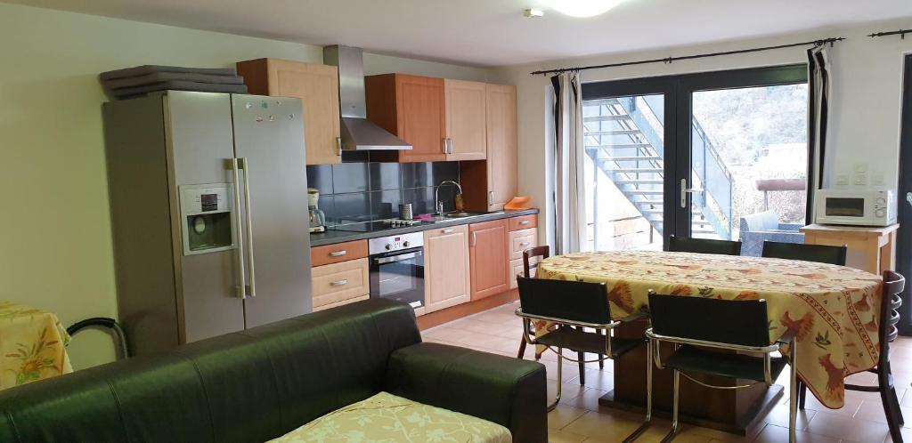 a kitchen with a table and a refrigerator and a table and chairs at Presqu'île de Chooz in Chooz