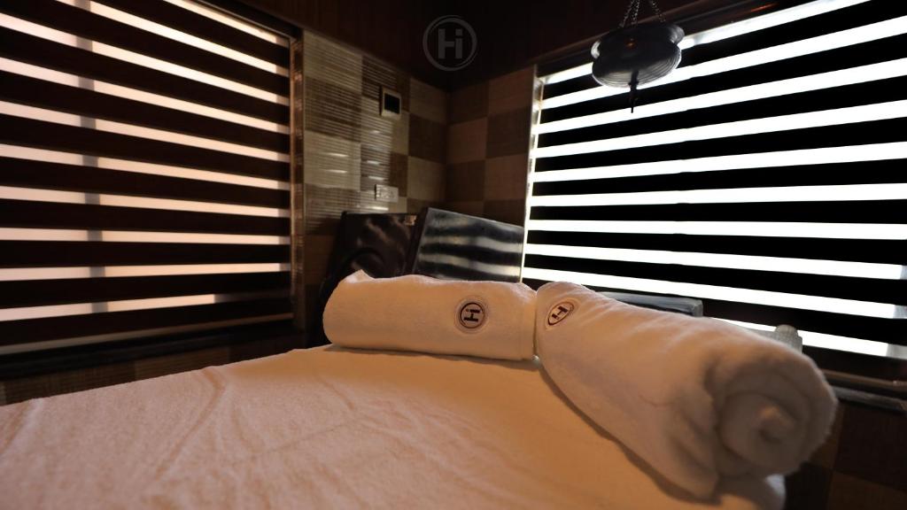 1 cama con edredón blanco en una habitación con ventanas en Harmony Inn, en Wayanad