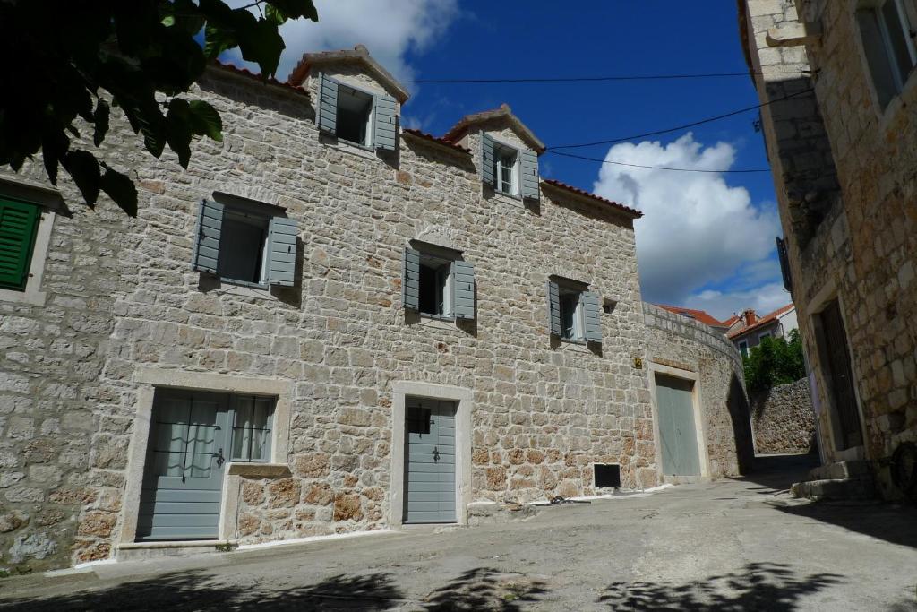 an old stone building with white doors and windows at Holiday Home Misir in Bol