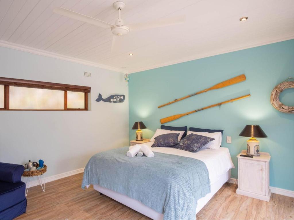 - une chambre avec un lit et un mur bleu dans l'établissement bWhale guest house, à Knysna