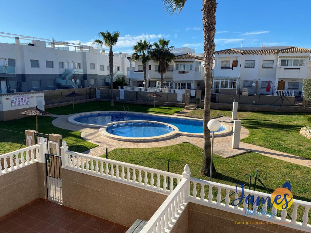 a view of a yard with a pool and buildings at La Ciñuelica, R3 1st Floor Apartment Com Pool L129 in Torrevieja