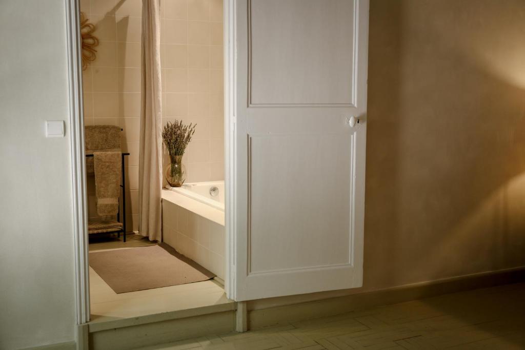 baño con bañera y puerta blanca en Mas des Prêcheurs, en Tarascon