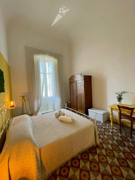 a bedroom with a bed with two towels on it at 4 Balconi House-Appartamento salentino nel centro di Lecce in Lecce