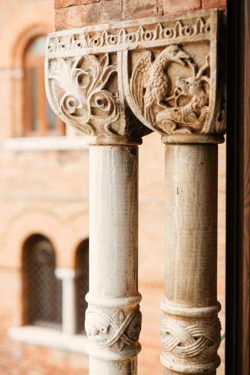 a column of a building with a statue on it at Palazzo Barocci in Venice