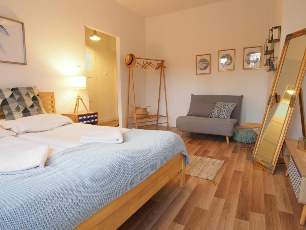 1 dormitorio con 1 cama y 1 silla en Grand-Tourist Iris Apartment K2202, en Gdansk