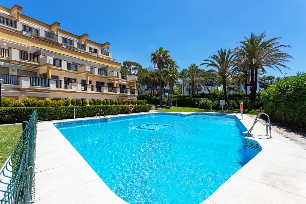 uma piscina em frente a um edifício em Romana Playa 132 Apartment by GHR Rentals em Marbella