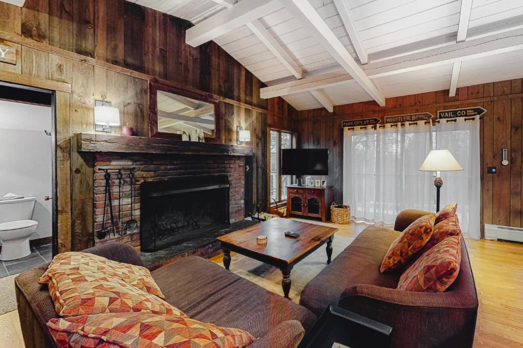 a living room with a couch and a fireplace at Chalet at the Base of Okemo Mountain in Ludlow