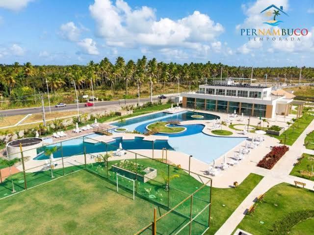 a resort with a swimming pool and a building at Muro Alto Clube Residence in Ipojuca