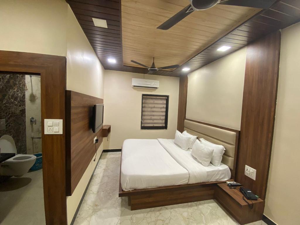 - une chambre avec un lit et un ventilateur de plafond dans l'établissement Hotel Samrat Ajmer, à Kokkíni Khánion