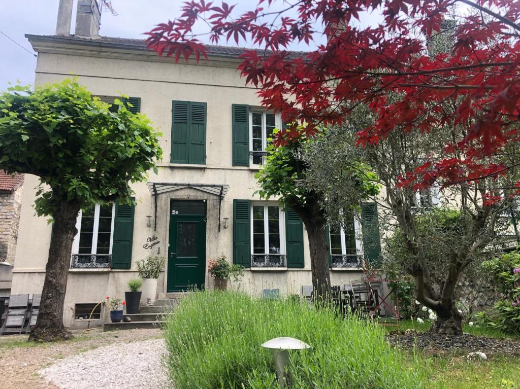 una casa antigua con una puerta verde y árboles en Villa Eugénie Melun, en Melun