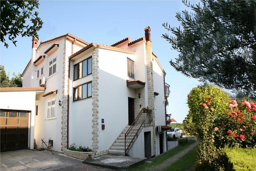 una casa blanca con una escalera delante en Apartments Maletić, en Kaštela