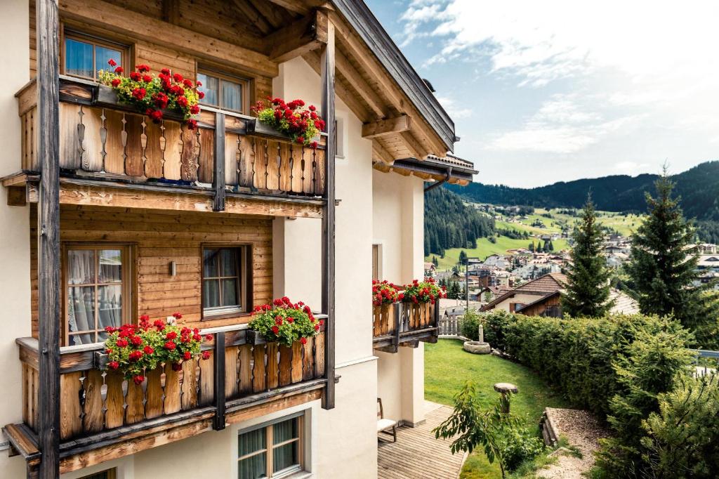 un edificio con fiori sui balconi con vista di App Lisüra Cir a Corvara in Badia
