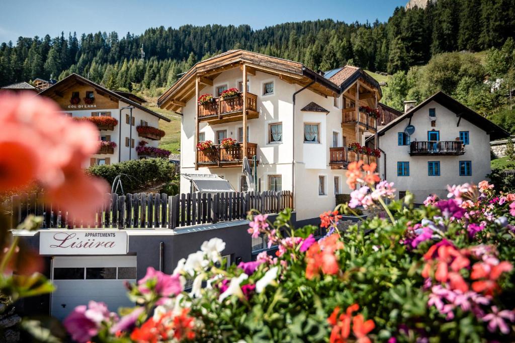a group of buildings with flowers in the foreground at App Lisüra Boè in Corvara in Badia
