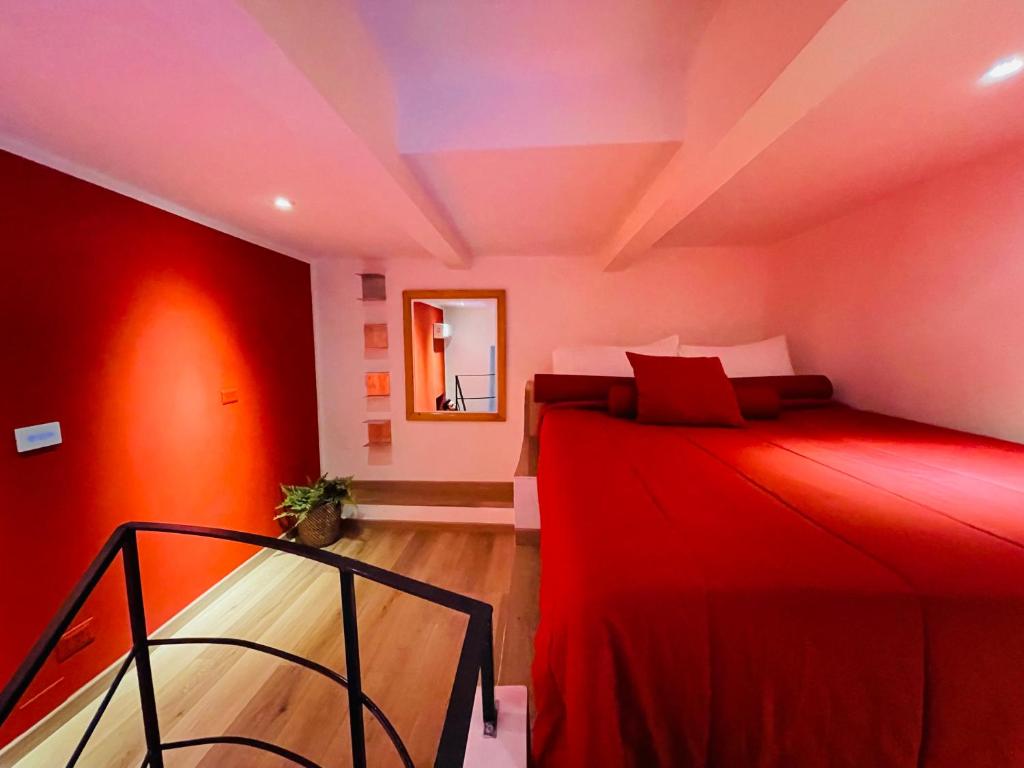 - une chambre avec un lit rouge et un miroir dans l'établissement Santa Maria La Nova 21 Rooms & Suites, à Naples