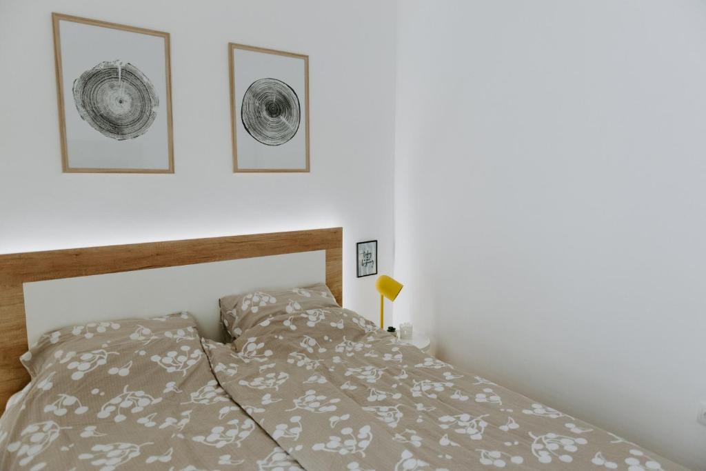 een slaapkamer met een bed en drie foto's aan de muur bij Apartman SREBRNA PAHULJA in Divčibare