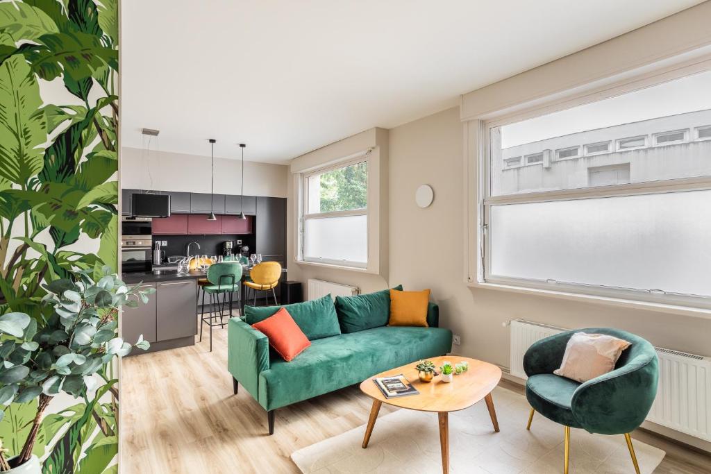 a living room with a green couch and a table at ARNEM - cosy T3 in Rennes