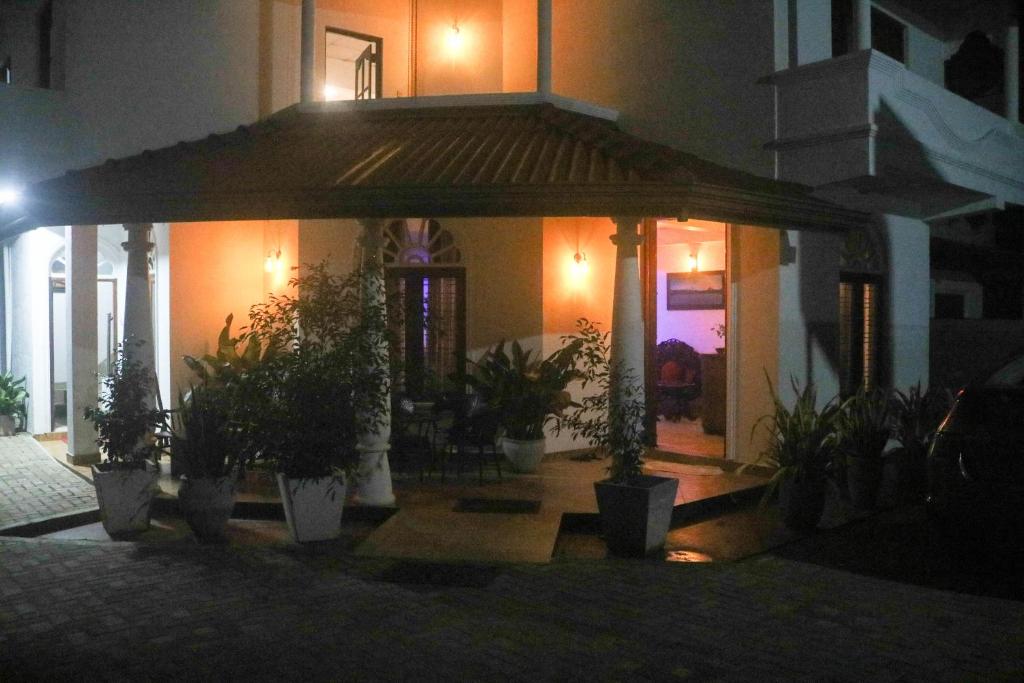 a building with a gazebo with potted plants in front at Thidasa Holiday Resort in Anuradhapura